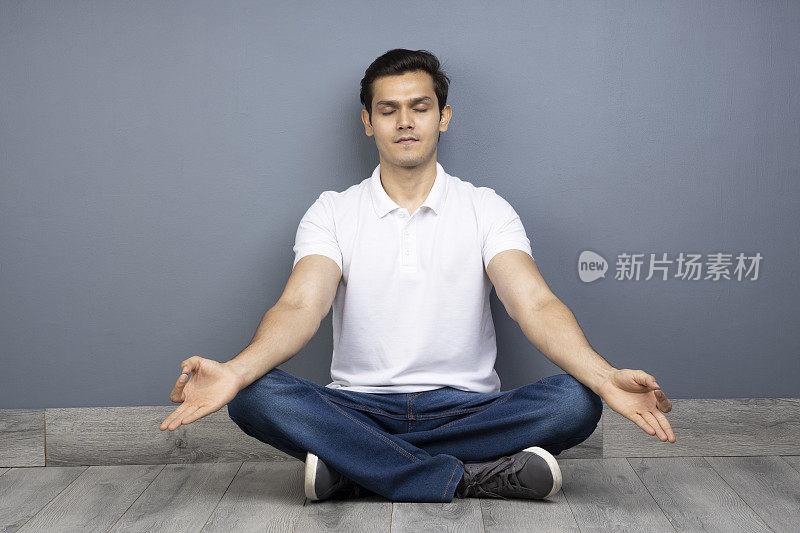 男人盘腿坐在地板上的stock photo